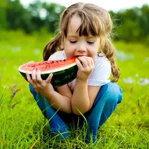 Little girl eating her watermelon.