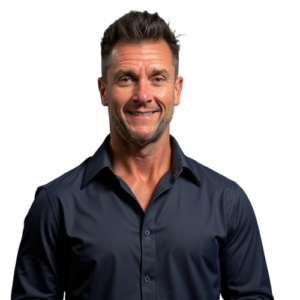 Dr_B | Neurofeedback Carolina Portrait of a smiling man wearing a navy dress shirt against a solid black backdrop.
